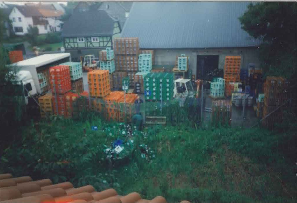Historische Hofansicht der alten Lagerhalle in der Karlstraße mit vielen gestapelten Getränkekisten und einem LKW (ca. 1989–1998).
