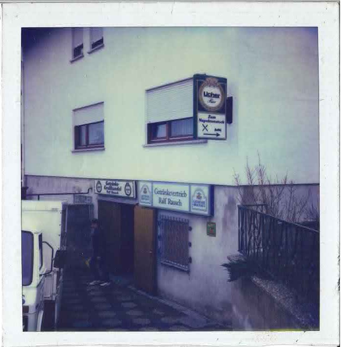 Historisches Foto eines Getränke-Verkaufs und Lagers (Zum Napoleonstock) mit Beschilderung ‚Getränkebetrieb Rausch‘, aufgenommen in den 1980er Jahren.